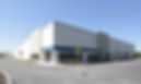 A wide-angle view of a large commercial warehouse and distribution facility in the Fife industrial corridor, highlighting the expansive perimeter and loading docks that require proactive mobile patrol and asset protection.