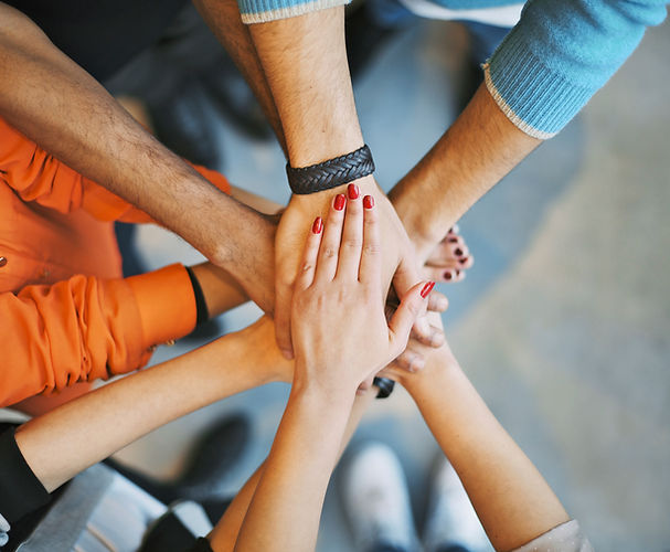 Many hands layering on top of each other in a show of team work.