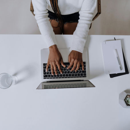 A woman typing on a laptop from bird eye view