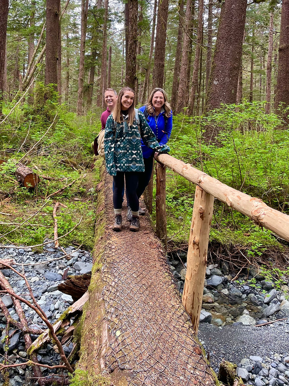 HIkers on log bridge on the Indian River Trail in Sitka Alaska