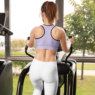 Woman exercising in gym wearing purple sports bra