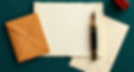 dark teal background with image of old fountain pen, letter paper, and envelopes_edited.jp