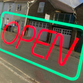 A neon window sign that says 'open'