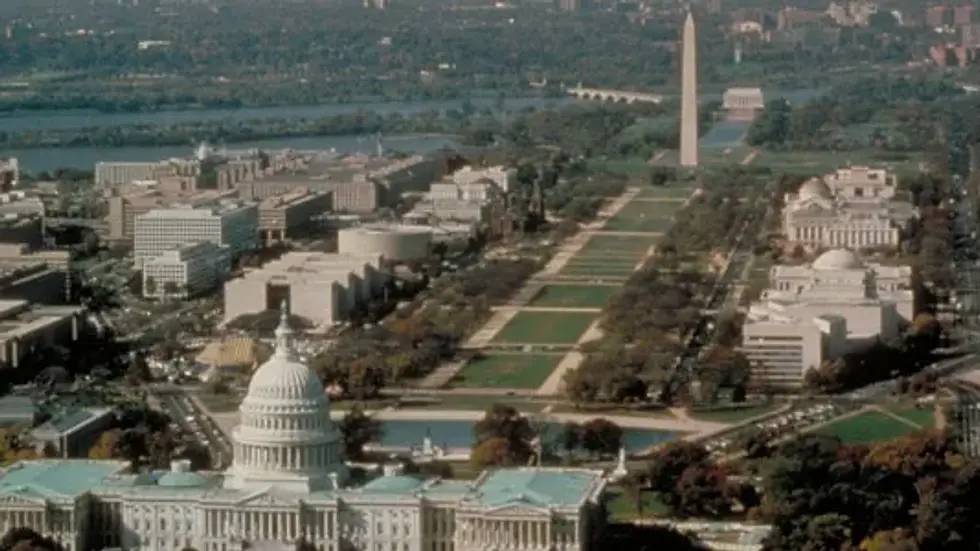 Aerial view of The Capitol and National Mall, Washington D.C., featuring the Washington Monument. Lush green space with surrounding buildings.