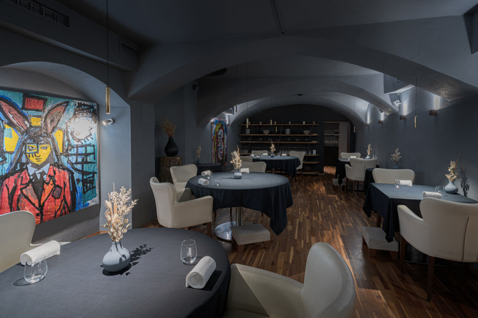 Eine Innenaufnahme von einem Restaurantraum. Die Tische sind für das Service gedeckt.