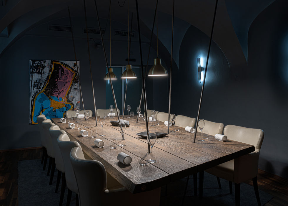 Ein großer Holztisch in einem Restaurantraum gedeckt mit Gläsern und weißen Servietten.