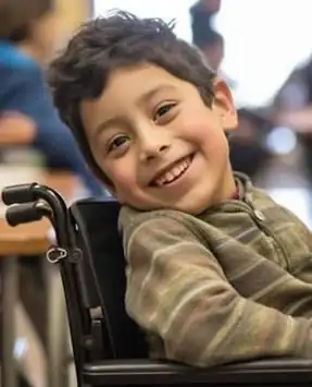 Smiling boy in a wheelchair at school