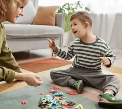 Caregiver playing a letter game with a young boy