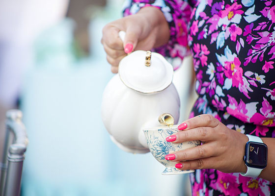 Freshly brewed tea into a teacup at a tea party