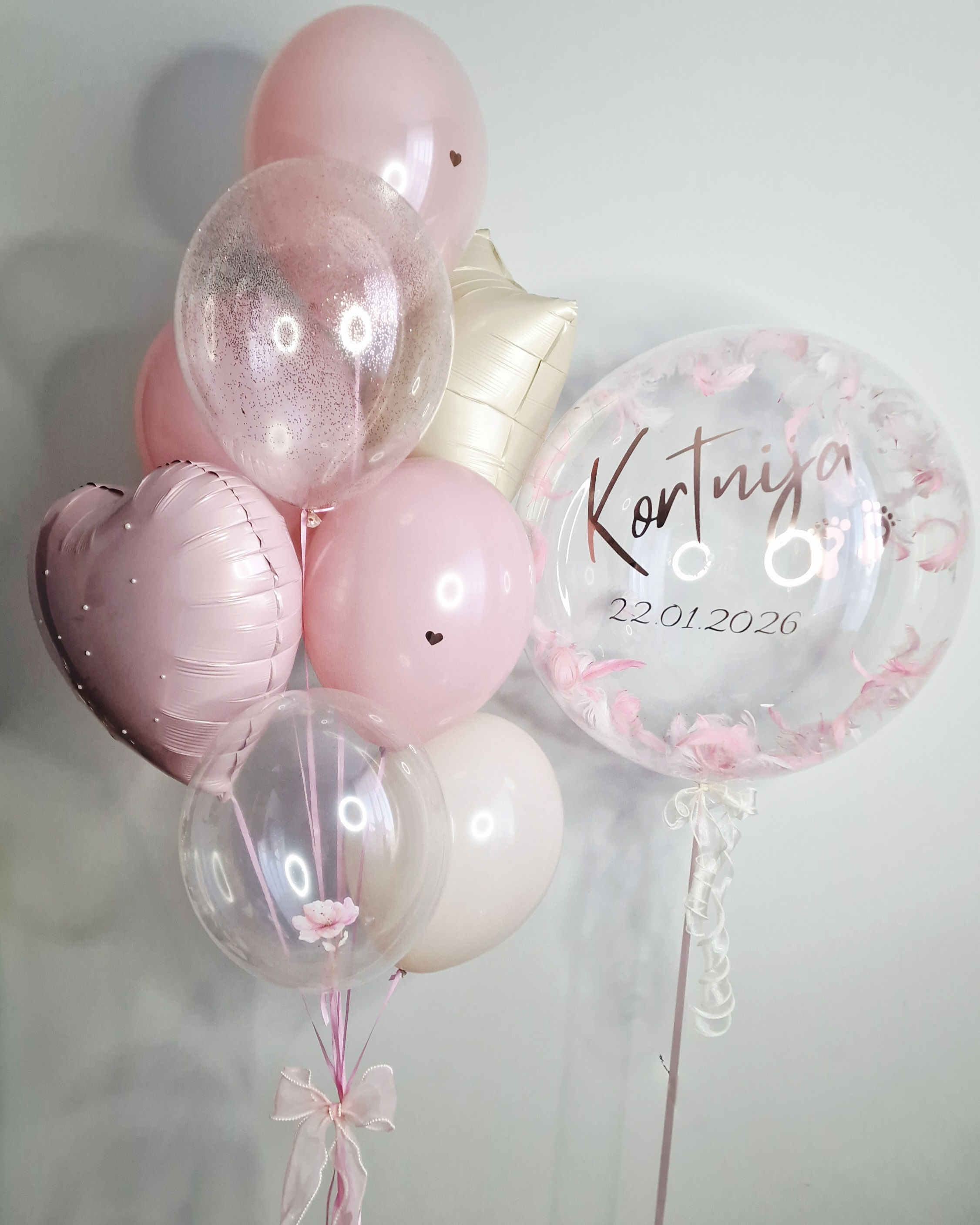 Kompozīcija ar caurspīdīgu sfēru un rozā balonu kompozīciju