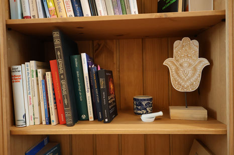 Ein Regalbrett mit schönen Elementen und Büchern in der Praxis Natalie Brucculeri