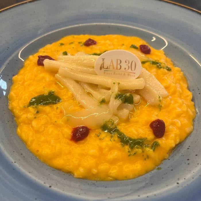 Cremiges Safran-Risotto mit Fenchel und Cranberries auf einem blauen Teller