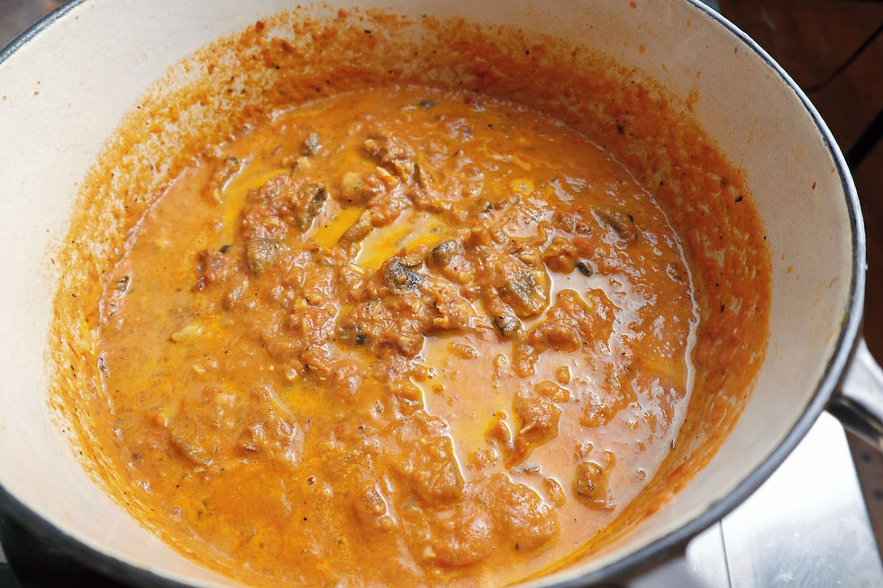 A pot of rich, rose pasta sauce with mushrooms and Prosciutto looks flavorful and aromatic, with a warm, inviting feel.