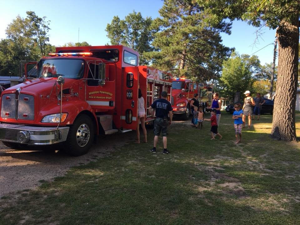 People lined up for a parade with firetrucks to celebrate the Fourth of July.