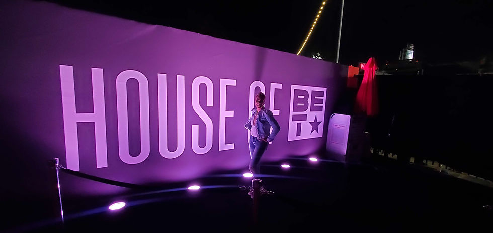 Crystal Marshall posing in front of an illuminated House of BET sign at a BET event.