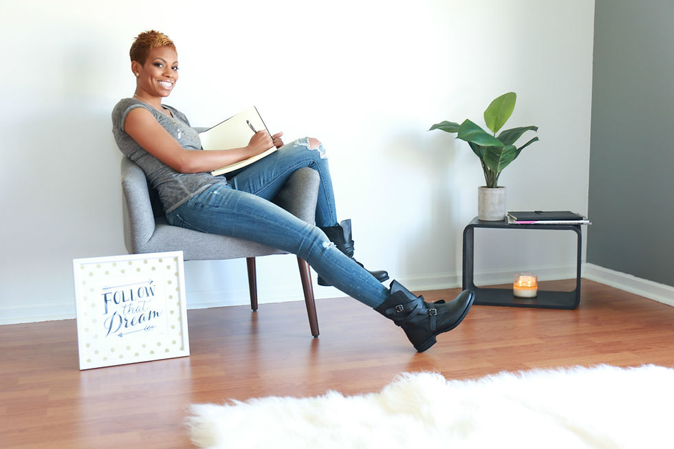 Crystal Marshall seated in a chair writing in a notebook, representing reflection, leadership, and the ongoing search for purpose.