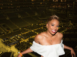 Crystal Marshall smiling confidently in a large event arena, representing calm, alignment, and leadership presence in high-pressure professional environments.