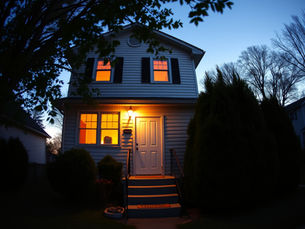Rental home at twilight with warm interior lights, illustrating umbrella insurance protection for landlords