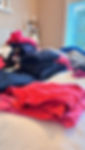 pile of clothes on bed to be sold after decluttering