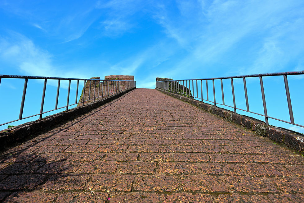 Steep stone pathway with railings leading up to a watchtower structure in Kasaragod under clear blue sky.