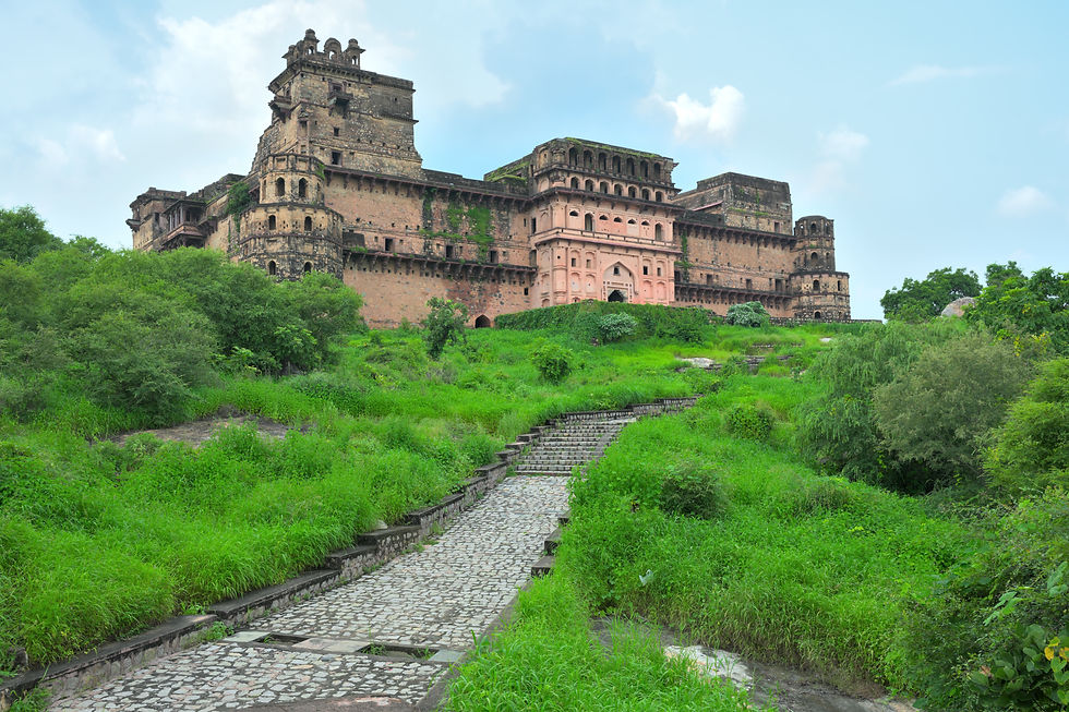 Staircase sections disappear beneath bastions and vegetation below Garh Kundar Fort.