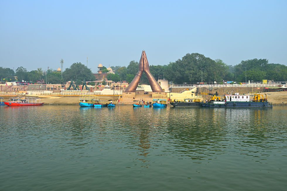 The large, folded-hands sculptures at Namo Ghat (formerly Khidkiya Ghat) in Varanasi, standing prominently by the Ganges River, symbolizing a namaskar.