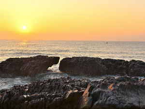 Sunrise over wave-carved rock formations at Thotlakonda Beach near Visakhapatnam on the Bay of Bengal coast.