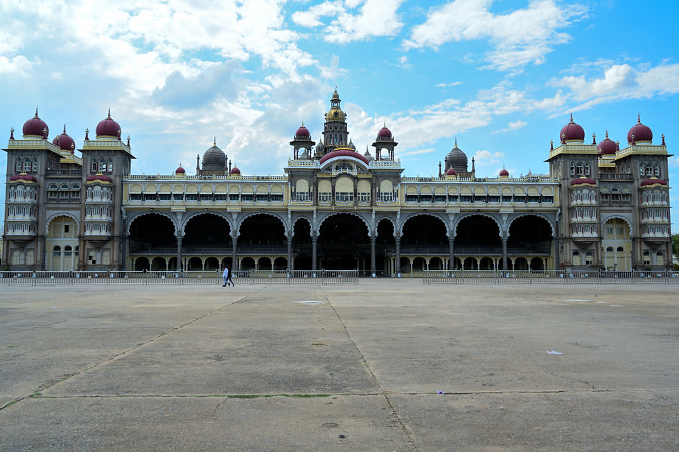 Wide shot of the symmetric Mysore Palace facade and courtyard under a cloudy sky. Shot with Nikon Z7.