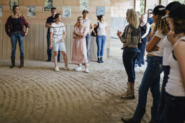 Firmen Event bei SaddleUp Coaching. Team steht in der Halle und Inhaberin und Coach, Simone Krebs erklärt.