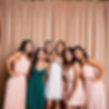 GROUP osing for a picture in front of a backdrop with a photo booth.jpg