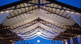 Barn ceiling with flowing drapery and chandeliers for rent