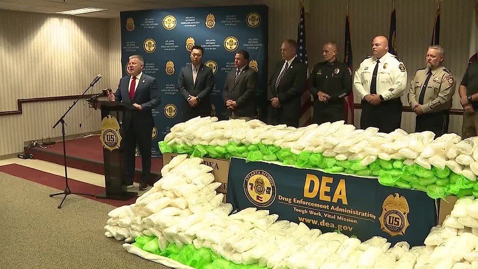 DEA evidence display (drugs/cash) at a press conference.