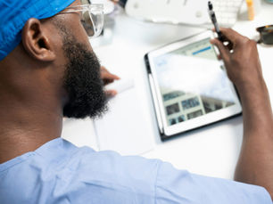 A nurse in scrubs with an ipad