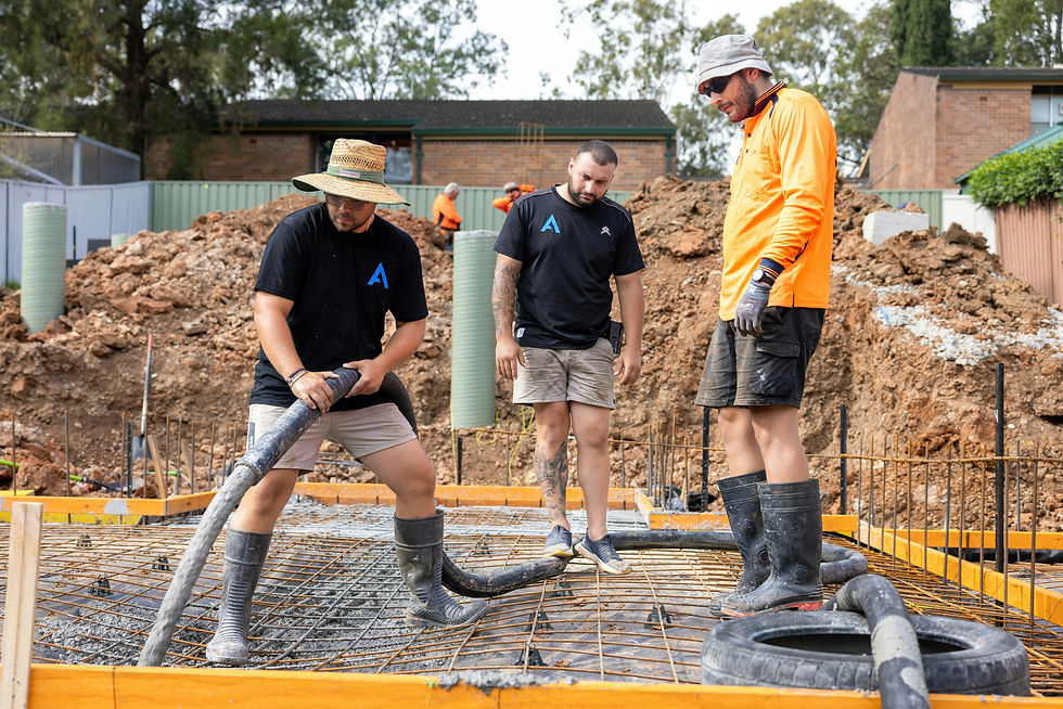Three construction workers pouring concrete