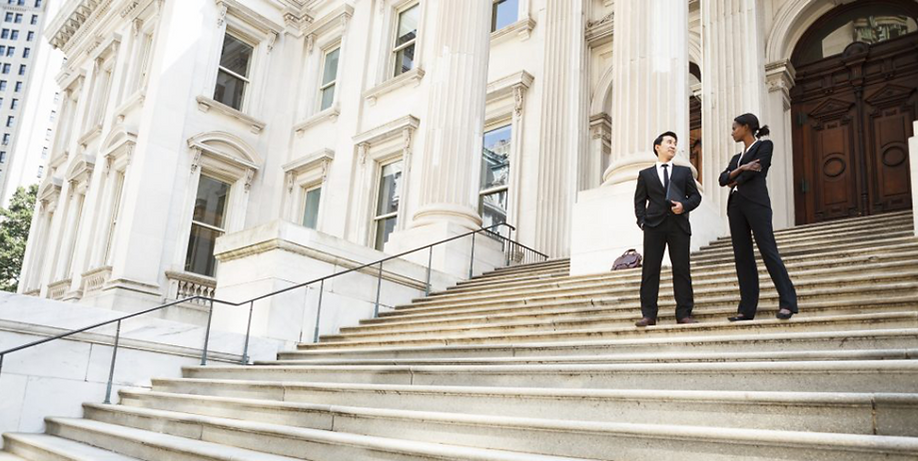 Legal professionals standing outside on steps of municipal building