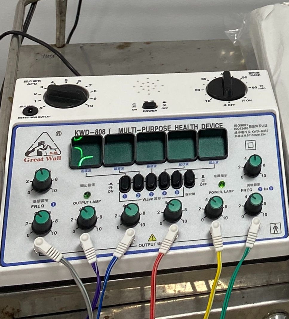 An enlarged image of the electroacupuncture machine. Labels are written in English and Chinese, hinting at its international usage.