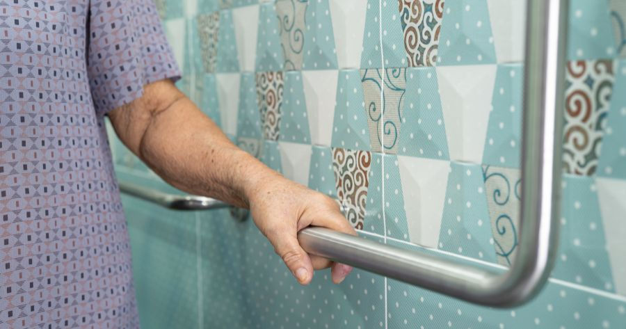 A senior holding onto grabrail