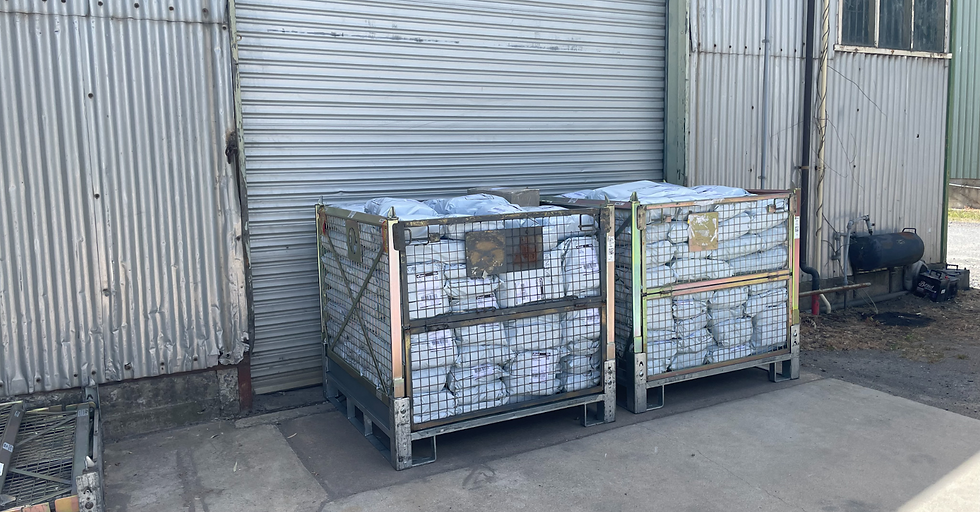 white bags in large metal crates sitting next to a shed