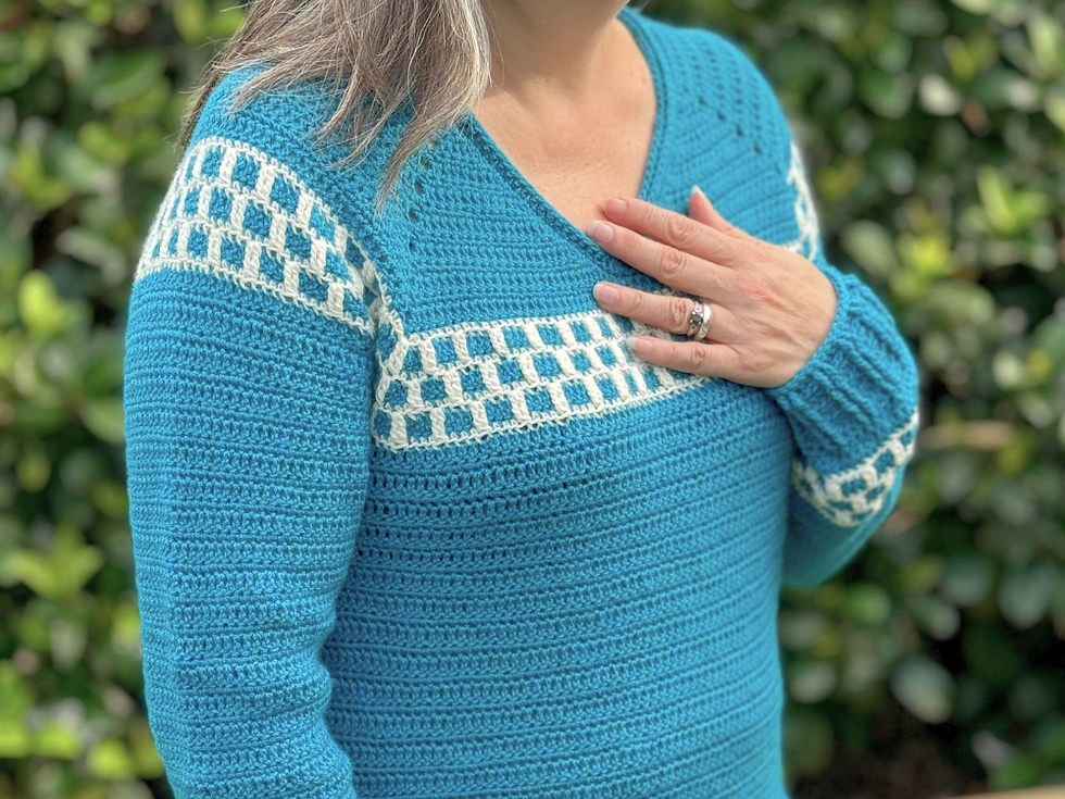 woman wearing a teal and white crocheted sweater