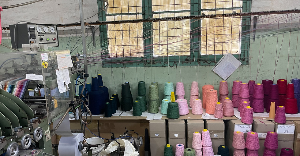 many cones of yarn with yarn fed into a machine