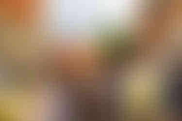 four piece band playing under a gazebo at music festival with audience sitting on picnic benches and standing