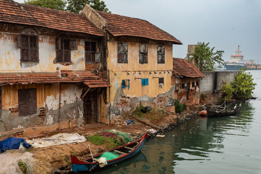 Terrace of houses on the water front with shipping tanker visible behind them