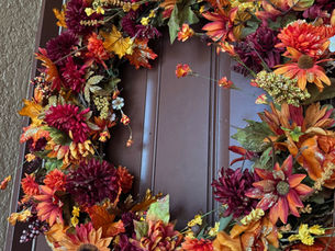 an autumn wreath hanging on a door