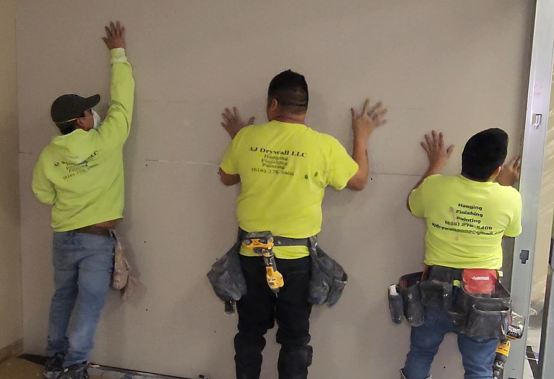 AJ Drywall crew hanging drywall in a commercial space