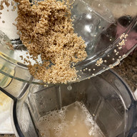 soaked quinoa being added to the blender 