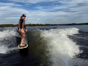 A woman wake surfs behind a boat on Lake Allatoona