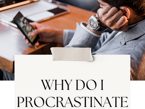 Man in gray suit sits at a desk, using a smartphone and looking at a laptop with bar charts in a warm office setting. with text overlay "why do I procrastinate so much"
