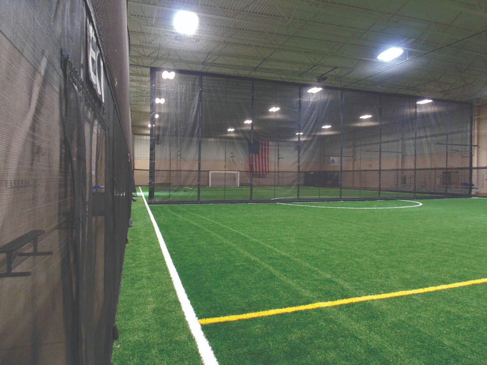 Indoor sports complex perimeter netting inside a private facility.