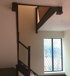Interior view of a staircase with a window and a wooden beam