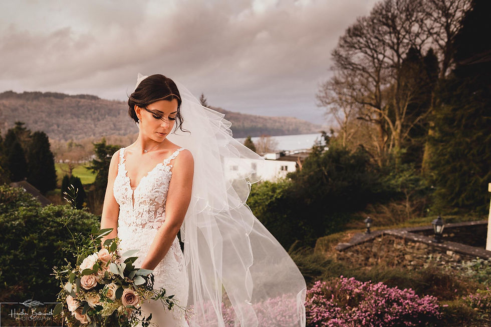 Bride Bex in the garden after their ceremony with her hair and veil blowing in the wind at The Burnside Hotel and Spa in Bowness-on-Windermere